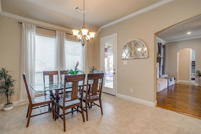 dining room with light tile patterned floors, visible vents, arched walkways, crown molding, and a chandelier