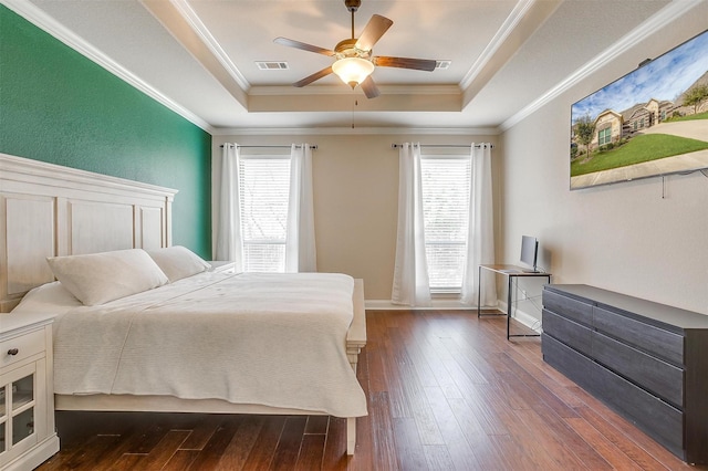 bedroom featuring visible vents, a raised ceiling, multiple windows, and dark wood finished floors