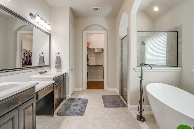 bathroom with vanity, visible vents, a freestanding tub, a stall shower, and a spacious closet