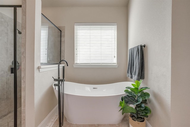 full bath with a freestanding tub, baseboards, and a stall shower