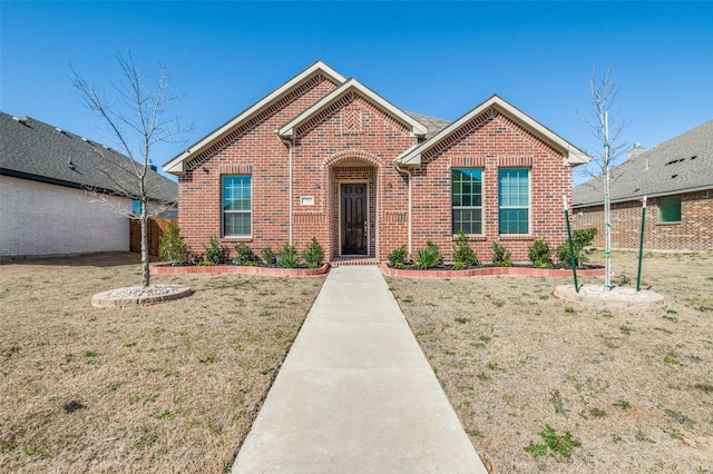 view of front of house with a front yard, fence, and brick siding