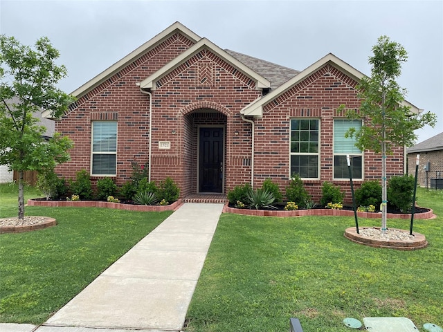 ranch-style home with brick siding and a front yard