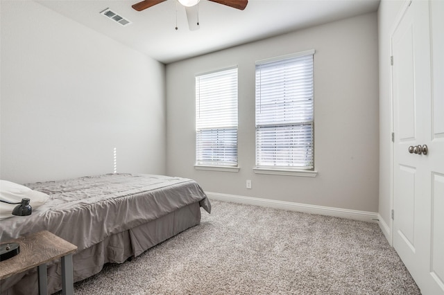 carpeted bedroom with a ceiling fan, baseboards, and visible vents