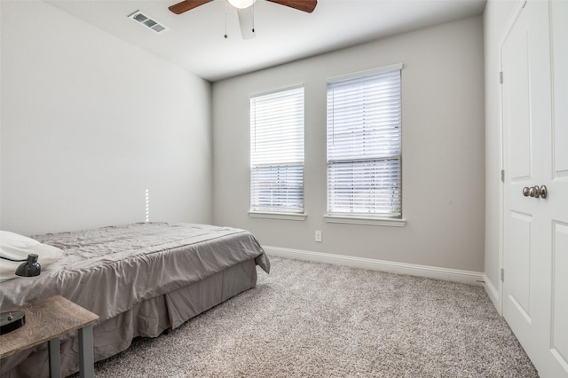 carpeted bedroom with baseboards, ceiling fan, and visible vents