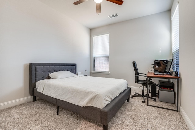 carpeted bedroom with visible vents, baseboards, and ceiling fan