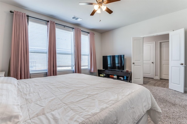 bedroom with vaulted ceiling, visible vents, carpet floors, and ceiling fan