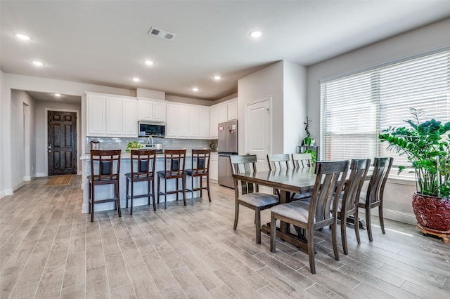 dining room with recessed lighting, baseboards, light wood-type flooring, and visible vents