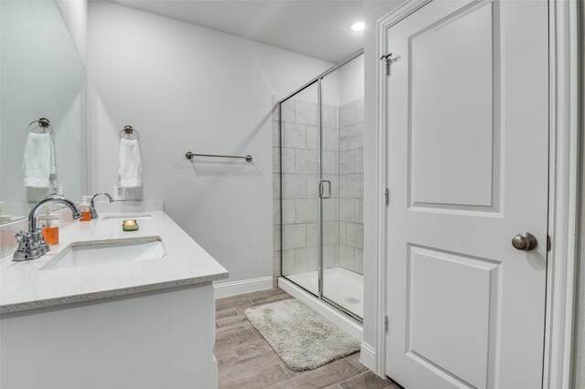 1521 Addison Dr, Lancaster, TX 75134 - bathroom with a sink, double vanity, baseboards, a shower stall, and wood tiled floor