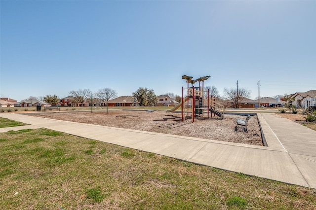 communal playground featuring a yard and a residential view
