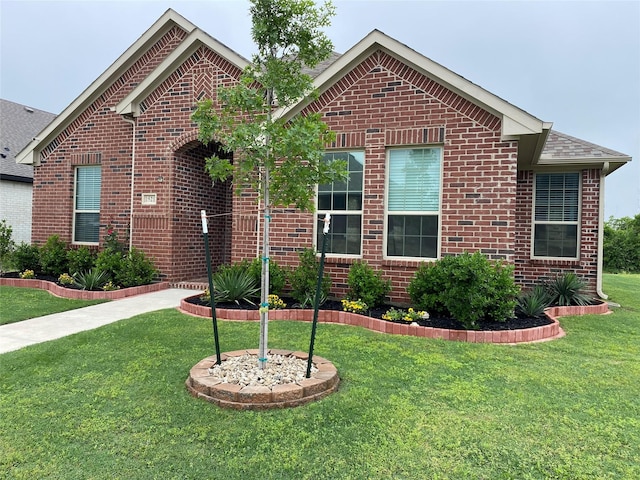view of front facade featuring brick siding and a front lawn