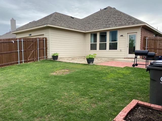 back of property with a lawn, fence, a patio area, and roof with shingles