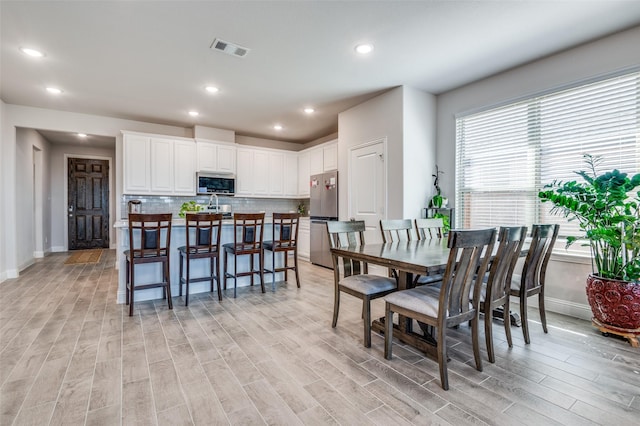 dining area featuring recessed lighting, visible vents, light wood-style flooring, and baseboards