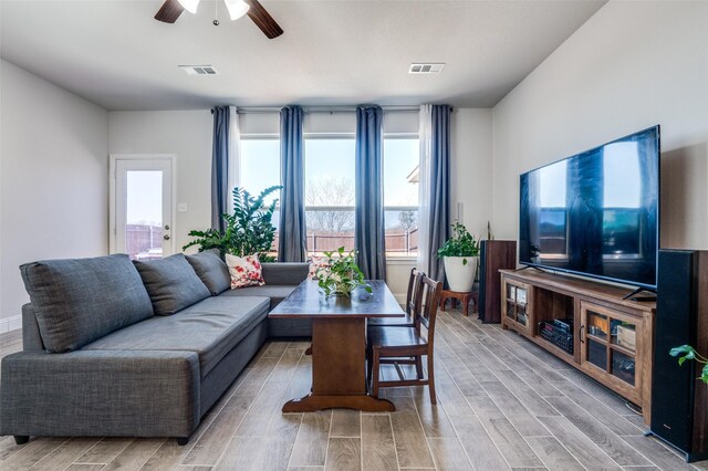 living area with visible vents, light wood-style floors, and ceiling fan