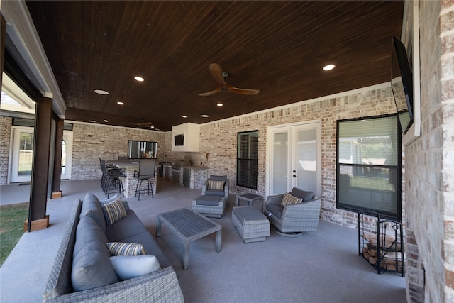 view of patio featuring outdoor lounge area, outdoor wet bar, area for grilling, and ceiling fan