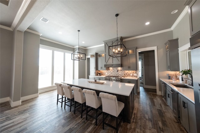 kitchen with visible vents, backsplash, a chandelier, stainless steel range, and a sink