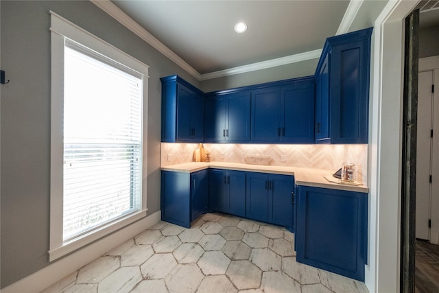 kitchen with decorative backsplash, light countertops, blue cabinets, and ornamental molding