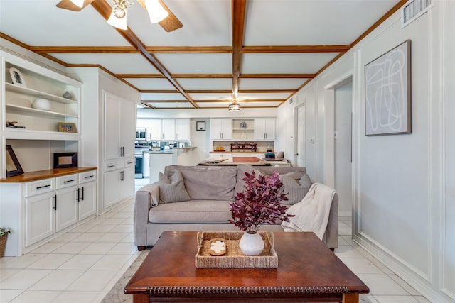 living room with light tile patterned flooring, visible vents, coffered ceiling, and a ceiling fan