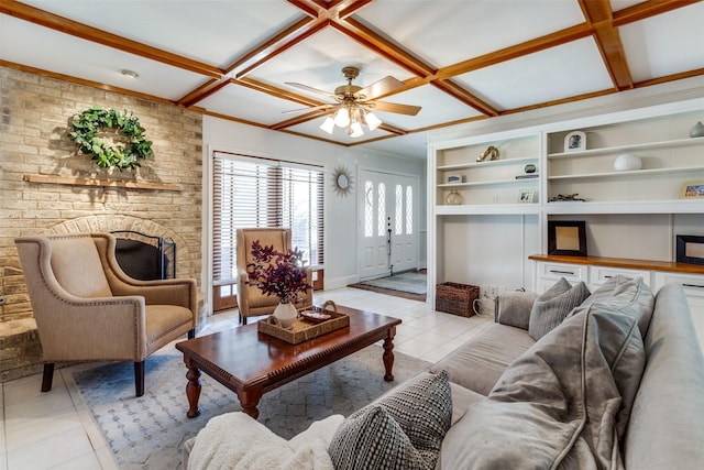 living area featuring built in shelves, light tile patterned floors, a ceiling fan, and coffered ceiling