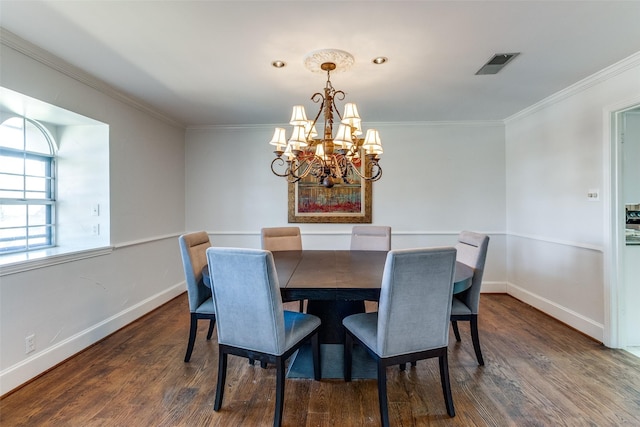 dining room with an inviting chandelier, wood finished floors, visible vents, and ornamental molding