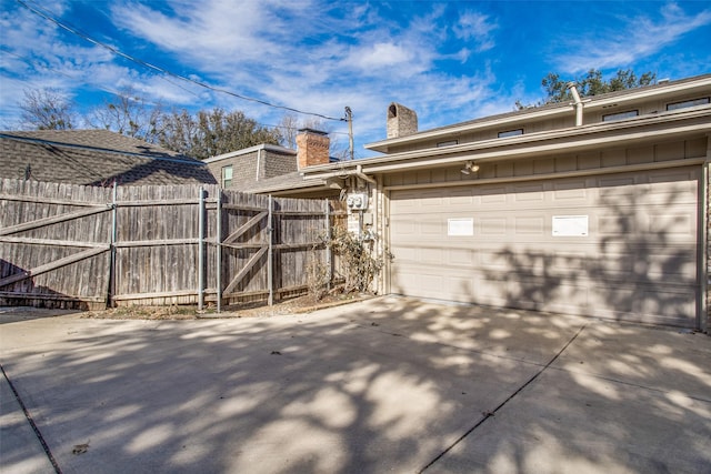 exterior space featuring concrete driveway and fence