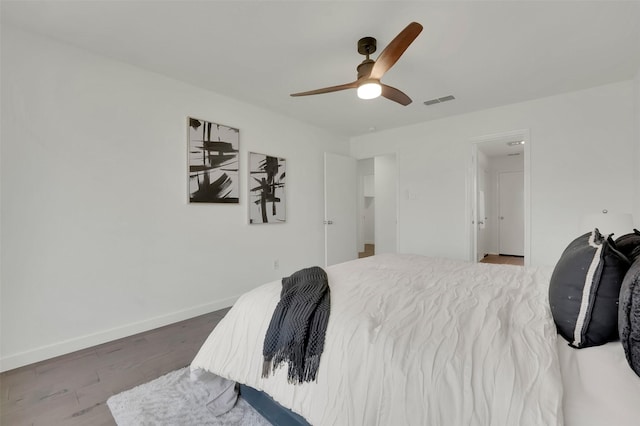 bedroom featuring visible vents, wood finished floors, baseboards, attic access, and ceiling fan