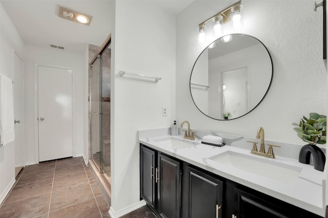 bathroom with a sink, visible vents, a stall shower, and tile patterned floors