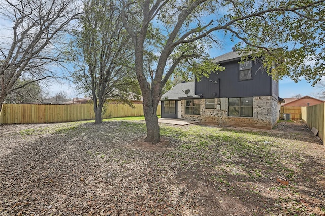 view of yard featuring central AC unit, a fenced backyard, and a patio area