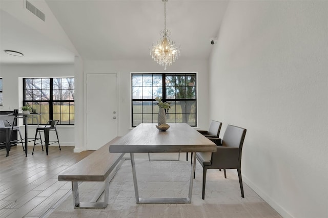 dining area featuring a wealth of natural light, visible vents, baseboards, and a chandelier