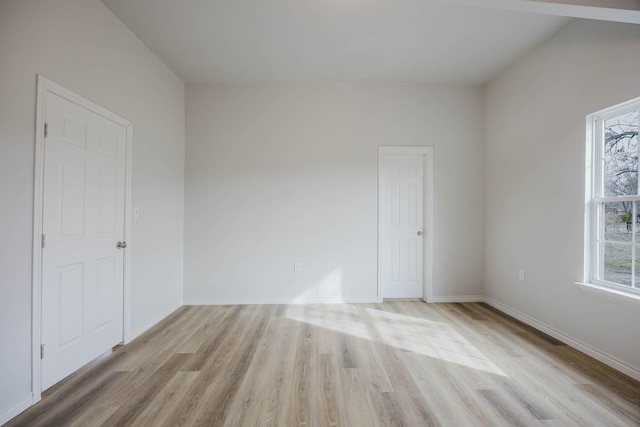 empty room with baseboards and light wood-style flooring