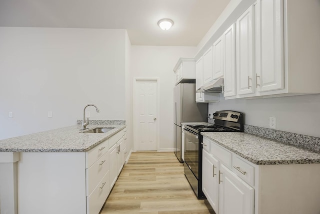 kitchen featuring black electric range oven, a sink, a peninsula, white cabinets, and light wood finished floors