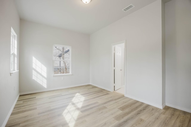 empty room with visible vents, baseboards, and light wood finished floors