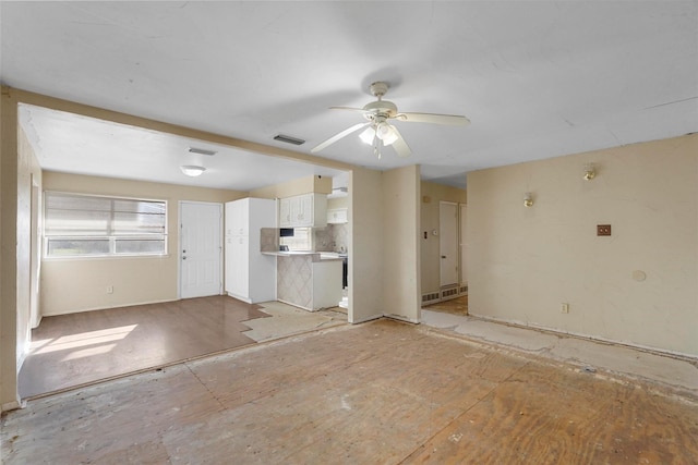 unfurnished living room featuring visible vents and ceiling fan