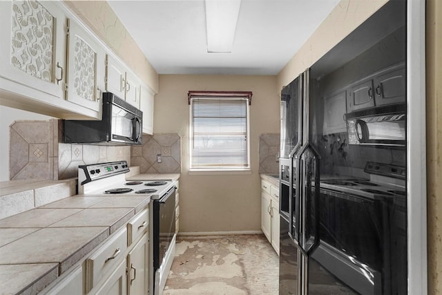 kitchen with tile countertops, electric range, and black microwave