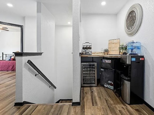 bar with dark wood-style floors, recessed lighting, and beverage cooler