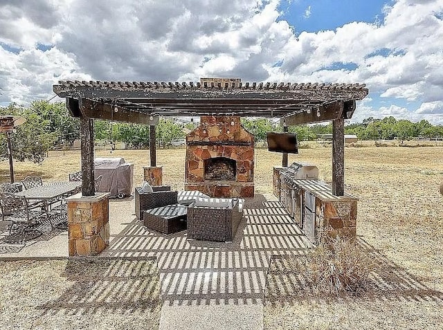 view of patio / terrace with an outdoor stone fireplace and a pergola