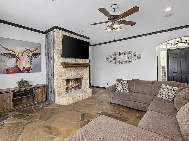 living room with a ceiling fan, stone finish floor, arched walkways, a fireplace, and crown molding