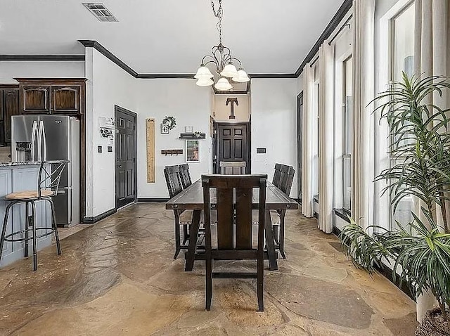 dining space featuring visible vents, a notable chandelier, ornamental molding, stone finish flooring, and baseboards