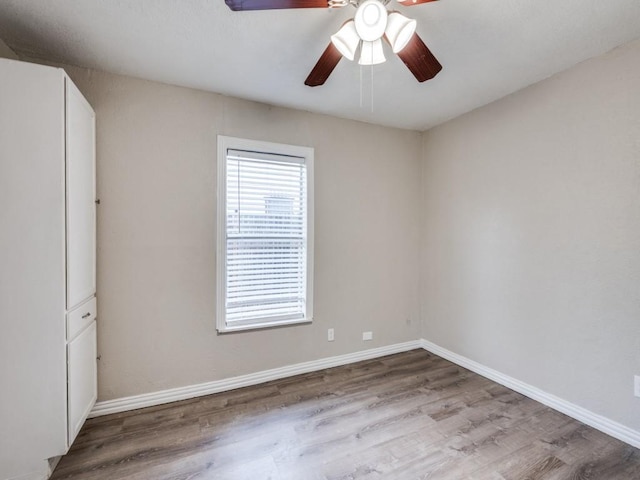 unfurnished room featuring baseboards, ceiling fan, and wood finished floors