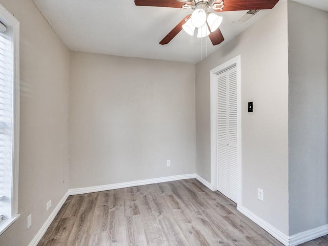 spare room with visible vents, baseboards, wood finished floors, and a ceiling fan