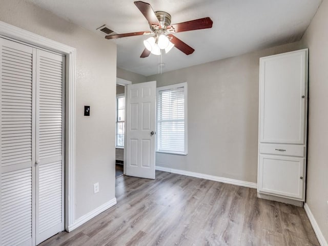 unfurnished bedroom with a ceiling fan, baseboards, visible vents, a closet, and light wood-type flooring