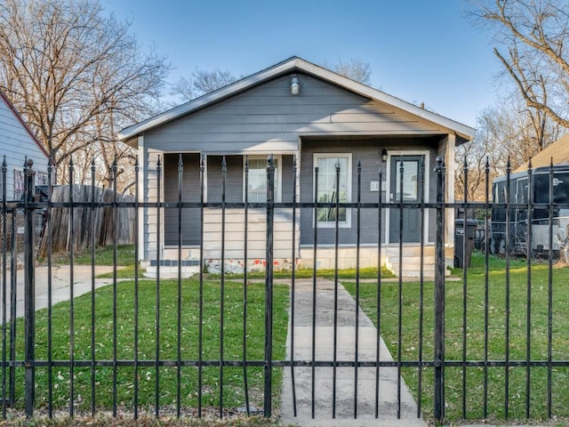 bungalow-style home featuring a gate, a front yard, and fence