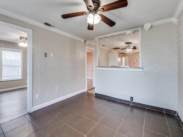 spare room with visible vents, baseboards, crown molding, and ceiling fan