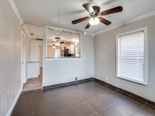 unfurnished living room featuring a textured wall, dark tile patterned flooring, ceiling fan, and ornamental molding