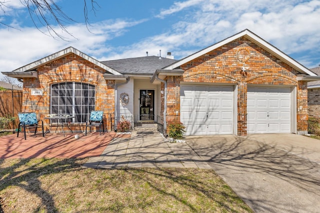 ranch-style home featuring brick siding, driveway, a garage, and roof with shingles