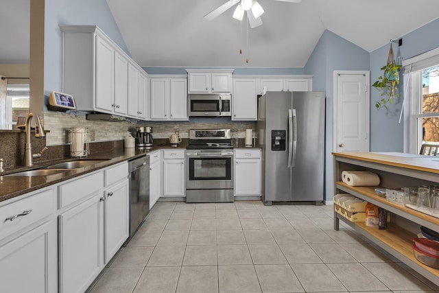 kitchen featuring a sink, lofted ceiling, appliances with stainless steel finishes, and white cabinetry