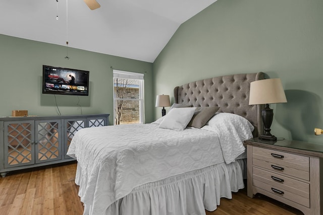 bedroom with a ceiling fan, lofted ceiling, and wood finished floors