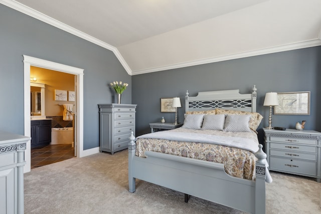 carpeted bedroom with baseboards, ensuite bath, crown molding, and lofted ceiling