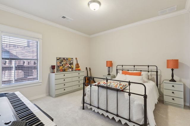 carpeted bedroom featuring visible vents, baseboards, and crown molding