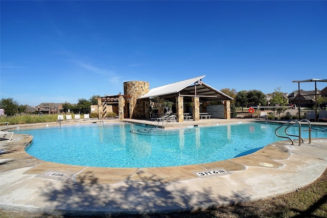 community pool with a gazebo, a patio, and fence