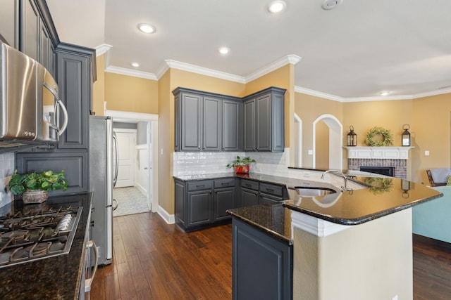 kitchen with dark wood-style flooring, gray cabinets, a sink, appliances with stainless steel finishes, and open floor plan